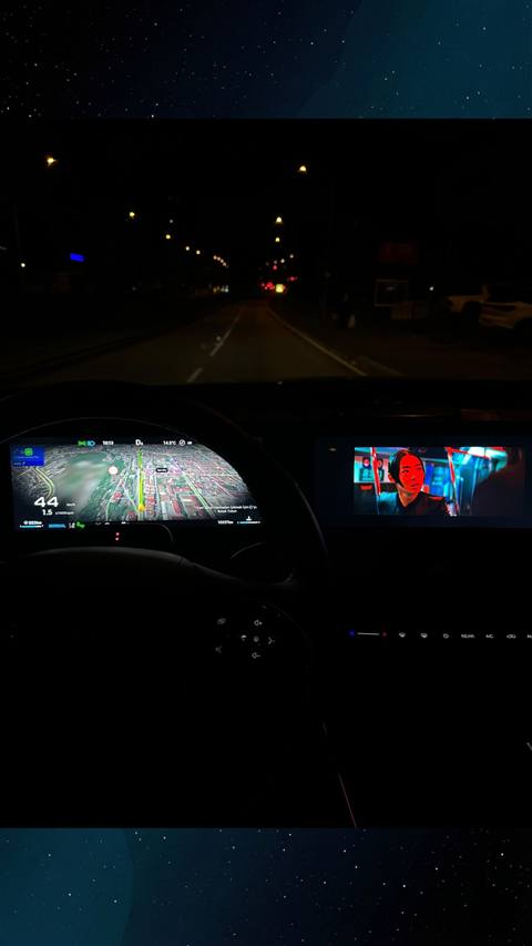 Gece vakti seyir halindeyken arac icinden on cam, navigasyon haritasi ve multimedya ekraninda film izlenirken cekilmis bir gorsel.