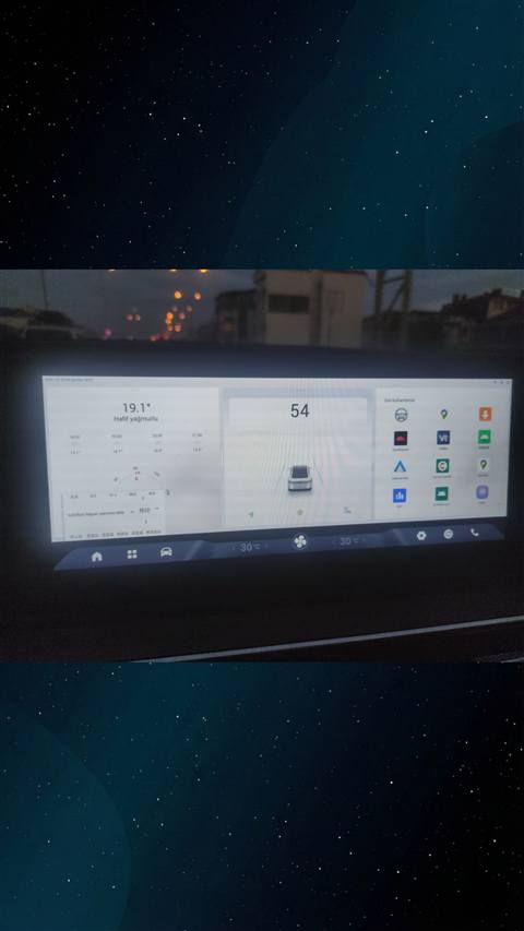 Bir Chery Tiggo aracinin multimedya ekraninda hava durumu, hiz gostergesi ve son kullanilan uygulamalarin goruntulendigi gece cekimi.
