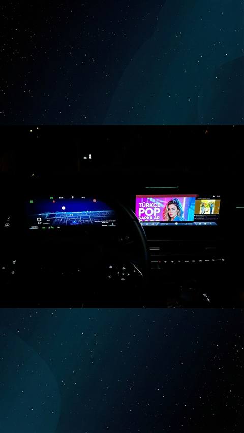 Araç içinden çekilmiş, sürücü gösterge panelinde navigasyon haritası ve orta ekranda Türkçe Pop Şarkılar müzik uygulamasının göründüğü karanlık bir kokpit fotoğrafı.