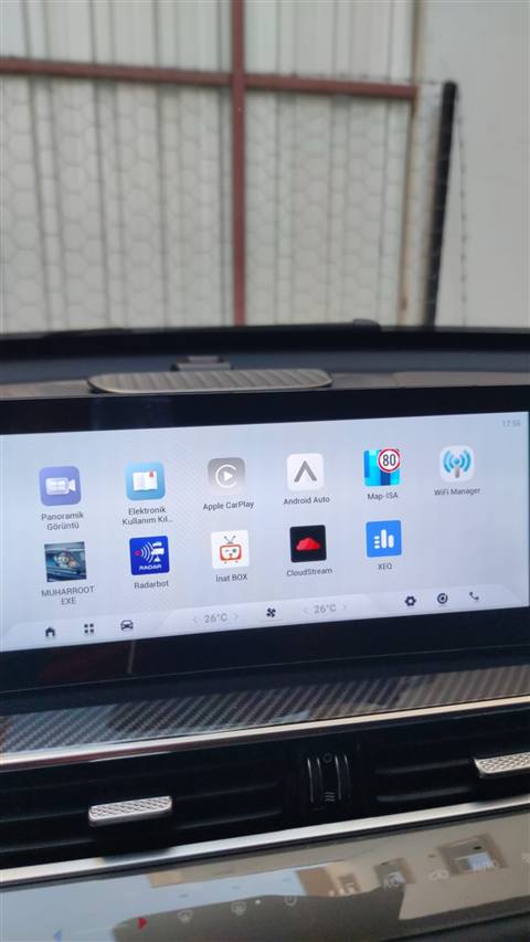 Bir aracin multimedya ekraninda CarPlay, Android Auto, radar ve diger uygulamalarin bulundugu ana menu goruntulenmektedir.