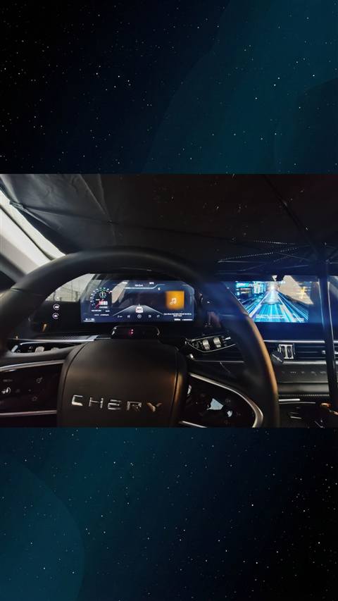 Chery marka bir aracin direksiyonu, dijital gosterge paneli ve merkezi multimedya ekraninin gece cekilmis ic mekan fotografi.