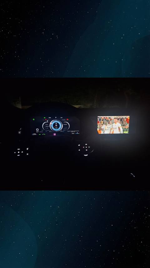 Bir aracin gece ici, dijital gosterge paneli ve navigasyon ekranini ayrica ikinci bir kucuk ekranda futbol mac yayinini gosteriyor.