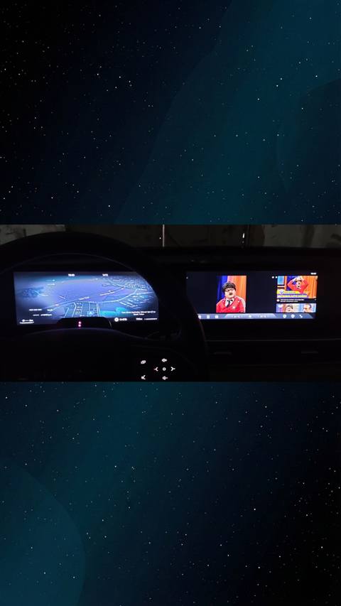 Bir aracin dijital gosterge panelinde navigasyon haritasi, orta ekranda ise televizyon yayini goruntulenmektedir.