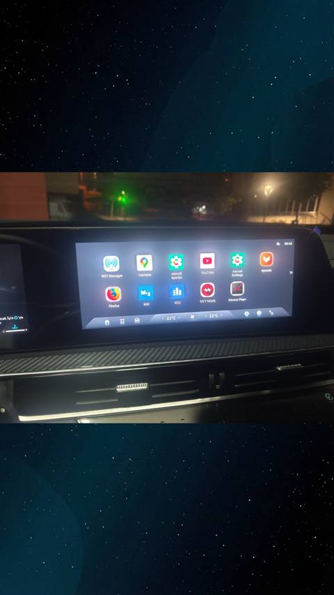Bir aracin multimedya ekraninda gece cekilmis, uygulama menusunun goruntulendigi bir fotograf.
