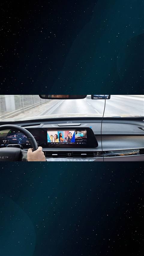 Bir aracin ic mekanindan, direksiyon ve multimedya ekraninda muzik/tv yayini ile navigasyon goruntulenen dashboard fotografi.