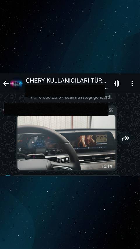 Chery arac kullanicilari WhatsApp grubunda paylasilan, direksiyon arkasindaki dijital gosterge panelinde navigasyon haritasi ve ortadaki multimedya ekraninda muzik/video oynatan bir arac ic mekan fotografi.