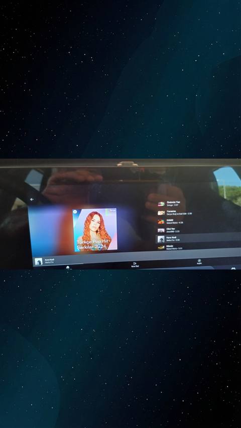 Araç multimedya ekranında Spotify uygulamasında Türkçe Pop Hit Şarkılar 2024 çalma listesinin görüntülendiği bir fotoğraf.