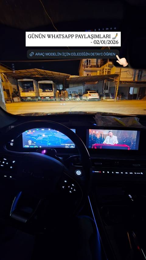 Gece vaktinde bir aracin ic mekanindan on cami ve dijital gosterge/multimedya ekranlari gorunmekte, navigasyon ve video ekranda acik.
