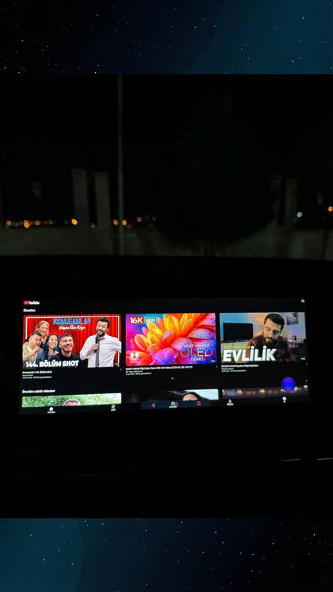 Araç multimedya ekranında YouTube uygulamasında önerilen videoların gösterildiği bir görüntü.