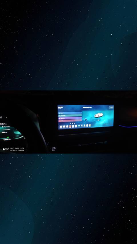 Bir aracin gece cekilmis multimedya ekrani ve dijital gosterge paneli goruntulenmektedir.