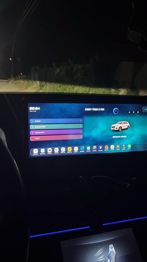 Gece vakti araç içinden çekilmiş, Chery Tiggo 8 Pro multimedya ekranının ana menüsünü gösteren bir fotoğraf.