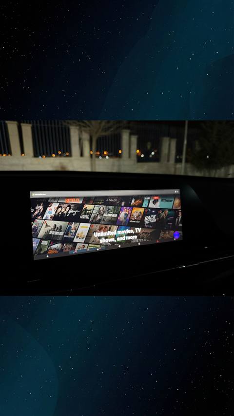 Araç multimedya ekranında Netflix web sitesinin gece vakti araç içinden görüntüsü.