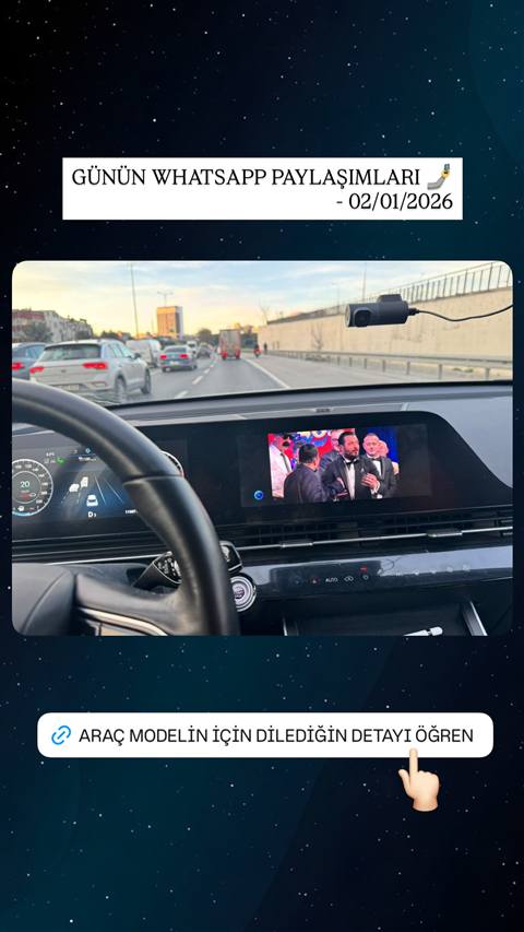 Araç içinden çekilmiş, direksiyon, dijital gösterge paneli ve multimedya ekranında video oynatılan bir sürüş anı görüntüsü.