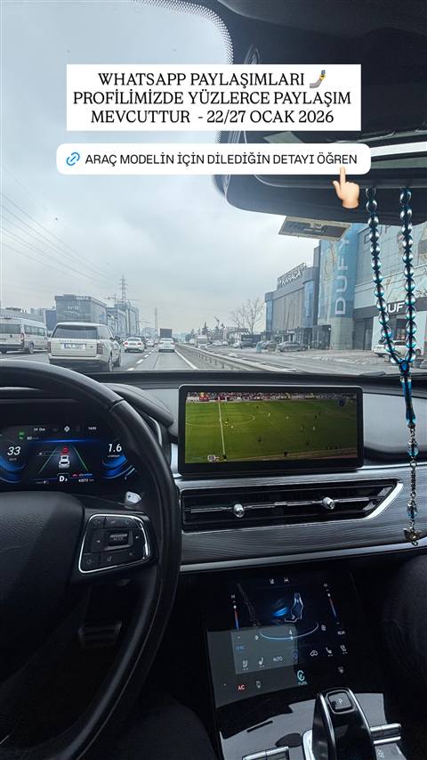 Bir aracin ic mekanindan trafikte seyir halindeyken multimedya ekraninda futbol mac yayini ve dijital gosterge paneli gorunmekte, ustunde WhatsApp paylasimlari duyurusu bulunuyor.